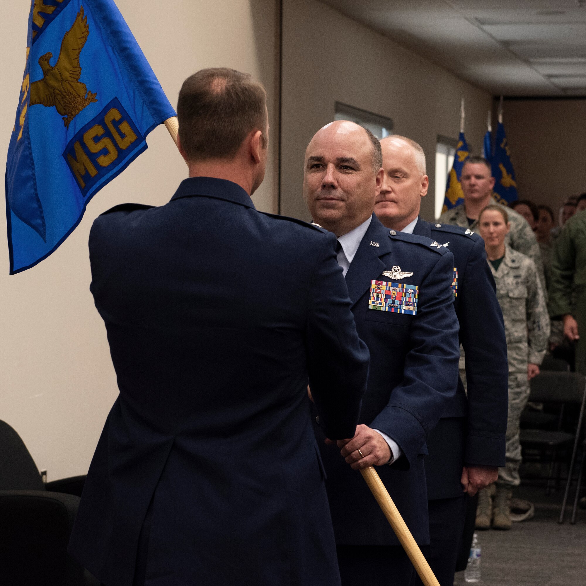 Col. Johan Deutscher, 141st Air Refueling Wing commander, passes the 141st Mission Support Group guidon to Col. David Kimpel, 141st MSG commander, during a change of command ceremony October 13, 2018 at Fairchild Air Force Base, Wash. During the ceremony, a guidon is passed to symbolize the passing of responsibility from one commander to another.(U.S. Air National Guard photo by Staff. Sgt. Rose M. Lust)