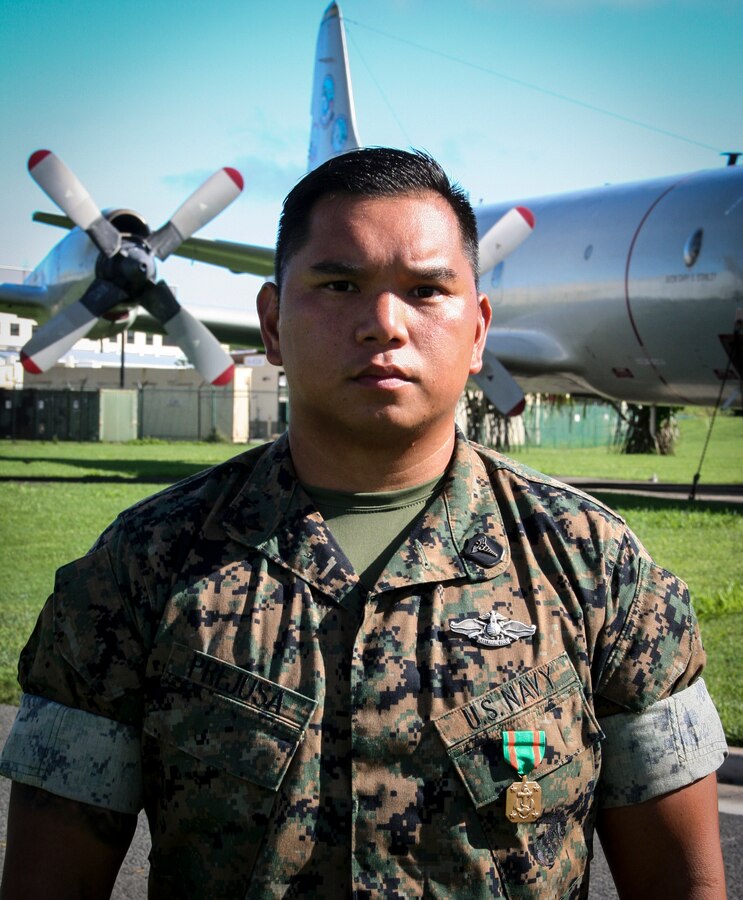 U.S. Navy Hospital Corpsman Second-Class Jephray Prejusa poses for photo after receiving Navy and Marine Corps Achievement Medal in front of Marine Aircraft Group 24, on October 1, 2018. HM2 Prejusa was awarded for rendering life-saving aid to a civilian aboard a commercial flight on August 4, 2018. (U.S. Marine Corps photo by 2nd Lt. Colin Kennard)
