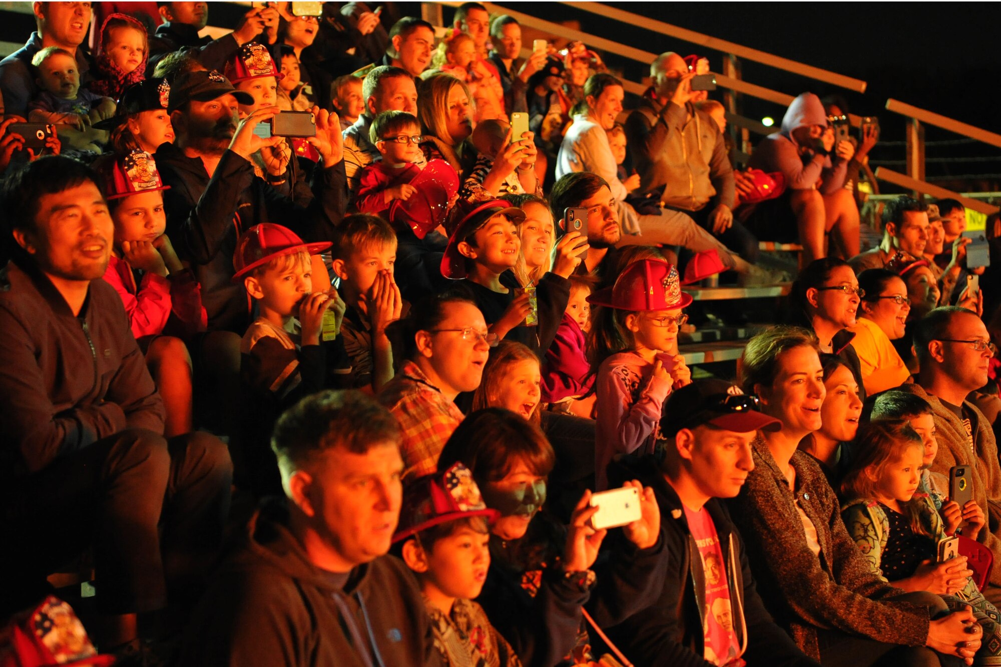 Audience members watch as firefighters from the 374th Civil Engineer Squadron put out a fire during a live fire demonstration