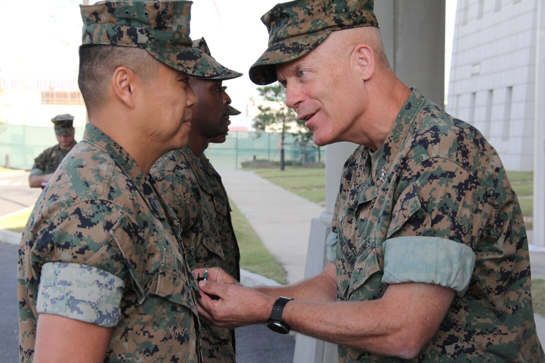 USAG CAMP HUMPHREYS, Republic of Korea – Maj. Gen. Patrick J. Hermesmann (right), commander of U.S. Marine Corps Forces Korea, awards Gunnery Sgt. Hung Tran, MARFORK G-1 administration chief, a Navy and Marine Corps Commendation Medal here, Oct. 4. Tran was awarded the medal for his superior performance at his previous unit, Manpower Management Integration Branch, Manpower Management Division. (U.S. Marine Corps photo by Staff Sgt. Anthony Kirby/Released)