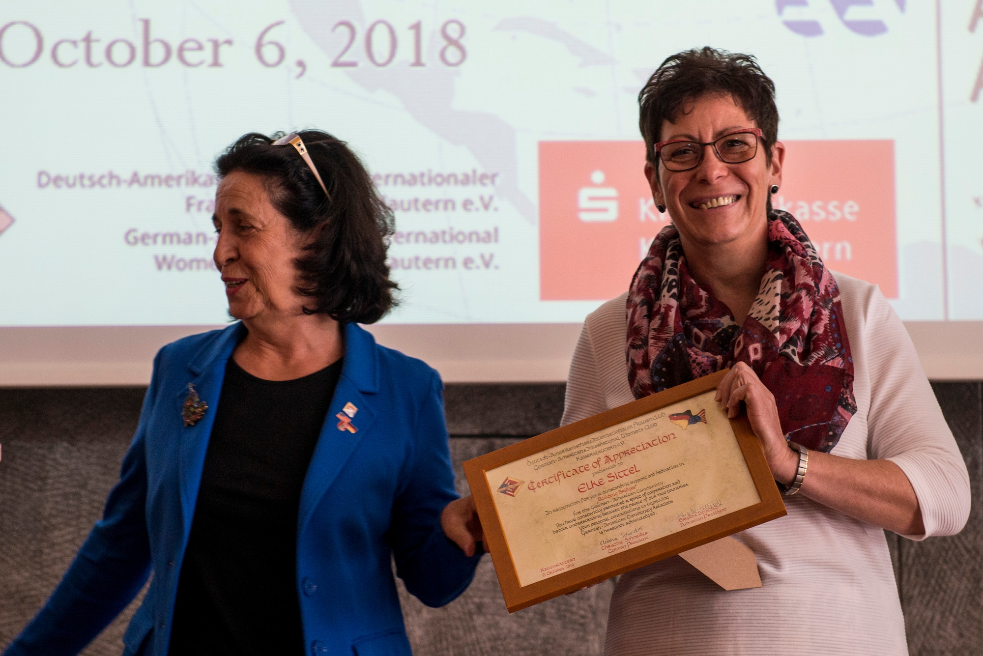 Elke Sittel, 86th Airlift Wing Host Nation official, smiles as she holds her recognition plaque during the 35th Annual German-American Day celebration in Kaiserslautern, Germany, Oct. 6, 2018. Sittel was recognized for her accomplishments in regards to trans-Atlantic relations. (U.S. Air Force photo by Staff Sgt. Jonathan Bass)