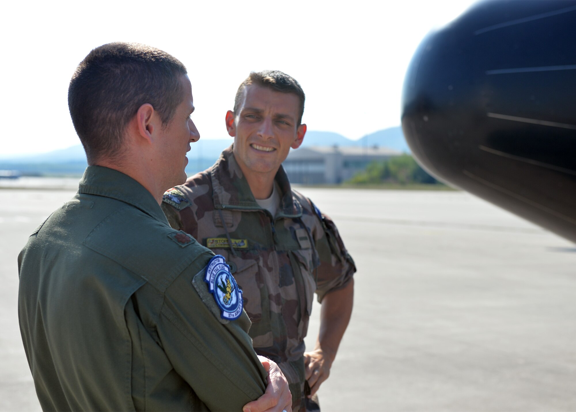 U.S. Air Force Maj. Matthew Hamblen, 37th Airlift Squadron standards and evaluations chief, speaks to a French C-130J Super Hercules aircraft pilot on Ramstein Air Base, Germany, Aug. 3, 2018. The 37th AS took an active role in assisting the French air force with their transition to the C-130J. (U.S. Air Force photo by Staff Sgt. Jimmie D. Pike)