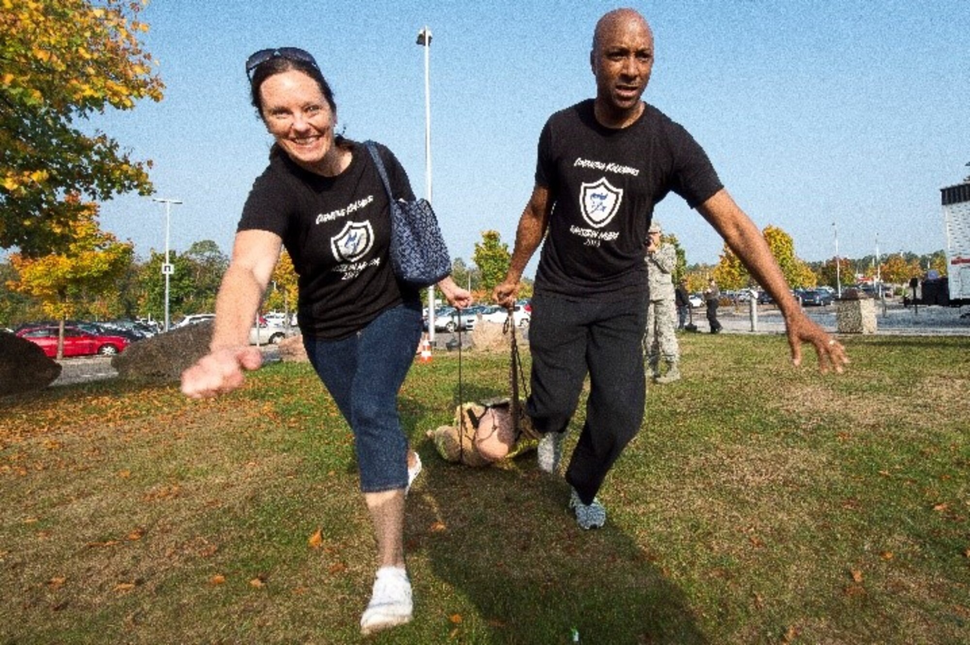 Nicole Shatto, Air Force Installation Contracting Agency procurement analyst, and  U.S. Air Force Chief Master Sgt. Robinson Joseph, AFICA chief enlisted manager, pull a dummy as part of the 86th Civil Engineer Squadron challenge during The Amazing Base competition on Ramstein Air Base, Germany, Oct. 10, 2018. The Amazing Base featured 15 locations across the base where teams completed challenges.