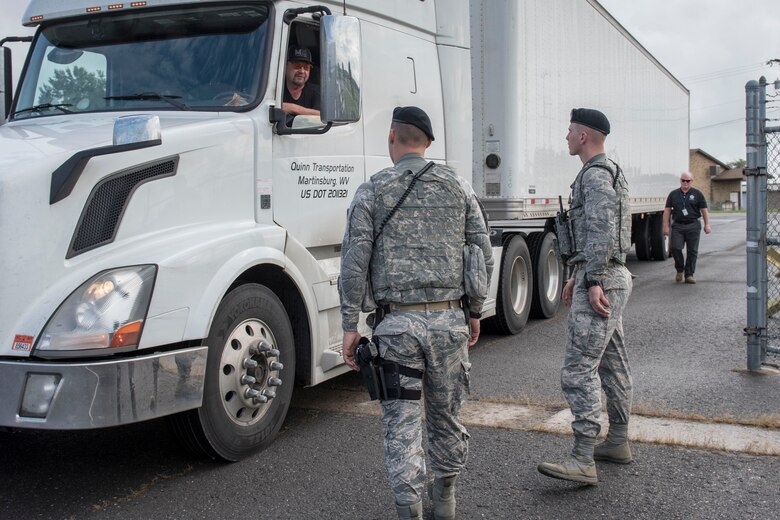 Airman 1st Class Braden Stutzman and Airman 1st Class Greg Tenney, 167th Airlift Wing Security Forces, greet a driver at a gate into the 167th Airlift Wing, Sept. 13. The tractor and trailer contained FEMA emergency relief supplies which were staged at the Martinsburg, W.Va. air base in anticipation of flooding from Hurricane Florence. (U.S. Air National Guard photo by Senior Master Sgt. Emily Beightol-Deyerle)