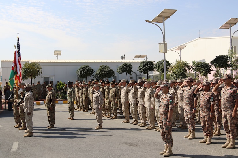 U.S. service members salute during the playing of the U.S. and Jordanian national anthems during a dedication ceremony for an expansion of the Jordan Armed Forces Joint Training Center Oct. 10, 2018. The new JTC wing provides U.S. service members a modern facility as U.S. forces and the Jordan Armed Forces continue to enhance interoperability by pursuing training opportunities together.
