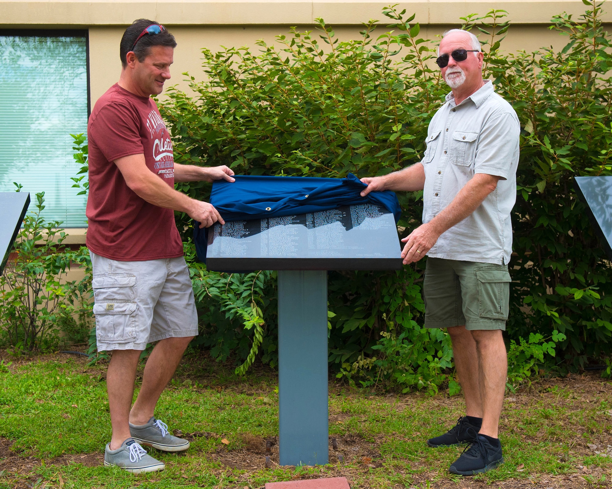 Retired Senior Master Sgt. Tony Pickman (left) and retired Chief Master Sgt. Tim Atwell unveil a plaque bearing the names of 36 Airmen who retired from the 123rd Airlift Wing in 2017 during a ceremony at the Kentucky Air National Guard Base in Louisville, Ky., Sept. 16, 2018. The annual unveiling celebrates Airmen who served for 20 or more years. (U.S. Air National Guard photo by Master Sgt. Vicky Spesard)