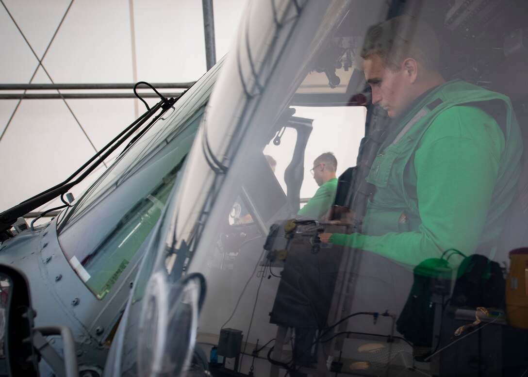 A Sailor aboard USNS Comfort conducts inspections on an MH-60S Seahawk helicopter.