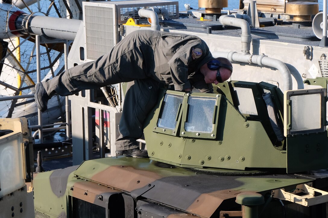 A U.S. Navy Sailor onboard a Landing Craft Air Cushion ensures U.S. Marine Corps vehicles are secure for flight at Mile Hammock Bay, Camp Lejeune, North Carolina, Oct. 5, 2018 in preparation to embark Marines and vehicles aboard USS Iwo Jima (LHD 7) during Type Commander Amphibious Training. TCAT allows the 24th Marine Expeditionary Unit, their subordinate units, and the U.S. Navy’s Iwo Jima Amphibious Ready Group to rehearse ship to shore maneuver and expeditionary command and control prior to exercise Trident Juncture 2018. The goal of TCAT is to increase unit and individual proficiency during amphibious operations. The Marines are with 2nd Battalion, 2nd Marines, 24th Marine Expeditionary Unit.  (U.S. Marine Corps photo by Gunnery Sgt. Robert Durham/released)