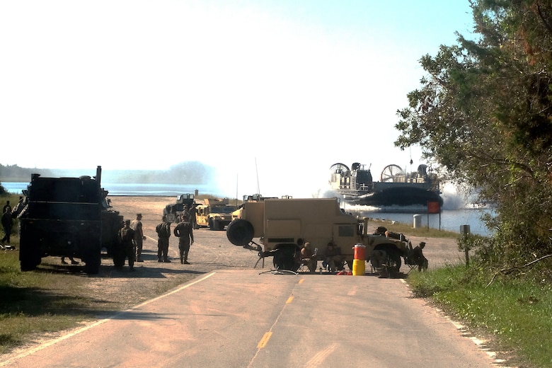 A U.S. Navy Landing Craft Air Cushion flies to Mile Hammock Bay, Camp Lejeune, North Carolina, Oct. 5, 2018 to onload Marines and vehicles during Type Commander Amphibious Training to embark aboard USS Iwo Jima (LHD 7). TCAT allows the 24th Marine Expeditionary Unit, their subordinate units, and the U.S. Navy’s Iwo Jima Amphibious Ready Group to rehearse ship to shore maneuver and expeditionary command and control prior to exercise Trident Juncture 2018. The goal of TCAT is to increase unit and individual proficiency during amphibious operations. The Marines are with 2nd Battalion, 2nd Marines, 24th Marine Expeditionary Unit.  (U.S. Marine Corps photo by Gunnery Sgt. Robert Durham/released)