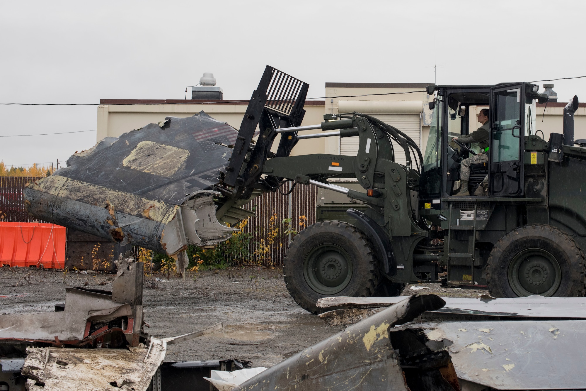 U.S. Air Force Airman 1st Class Pamela Proteau, a 773d Logistics Readiness Squadron vehicle operator, picks up part of a wing using a 10k all-terrain forklift to remove wreckage debris at Joint Base Elmendorf-Richardson, Alaska, Sept. 28, 2018. Proteau was part of a large wreckage disposal team whose mission was to remove debris from the fatal crash of the Sitka 43 C-17 Globemaster III that had been stored at JBER since 2010. After multiple shipments, the ‘Sitka 43’ wreckage is finding a new purpose at the Air Force Safety Center (AFSEC) Crash Lab at Kirtland Air Force Base, N.M.