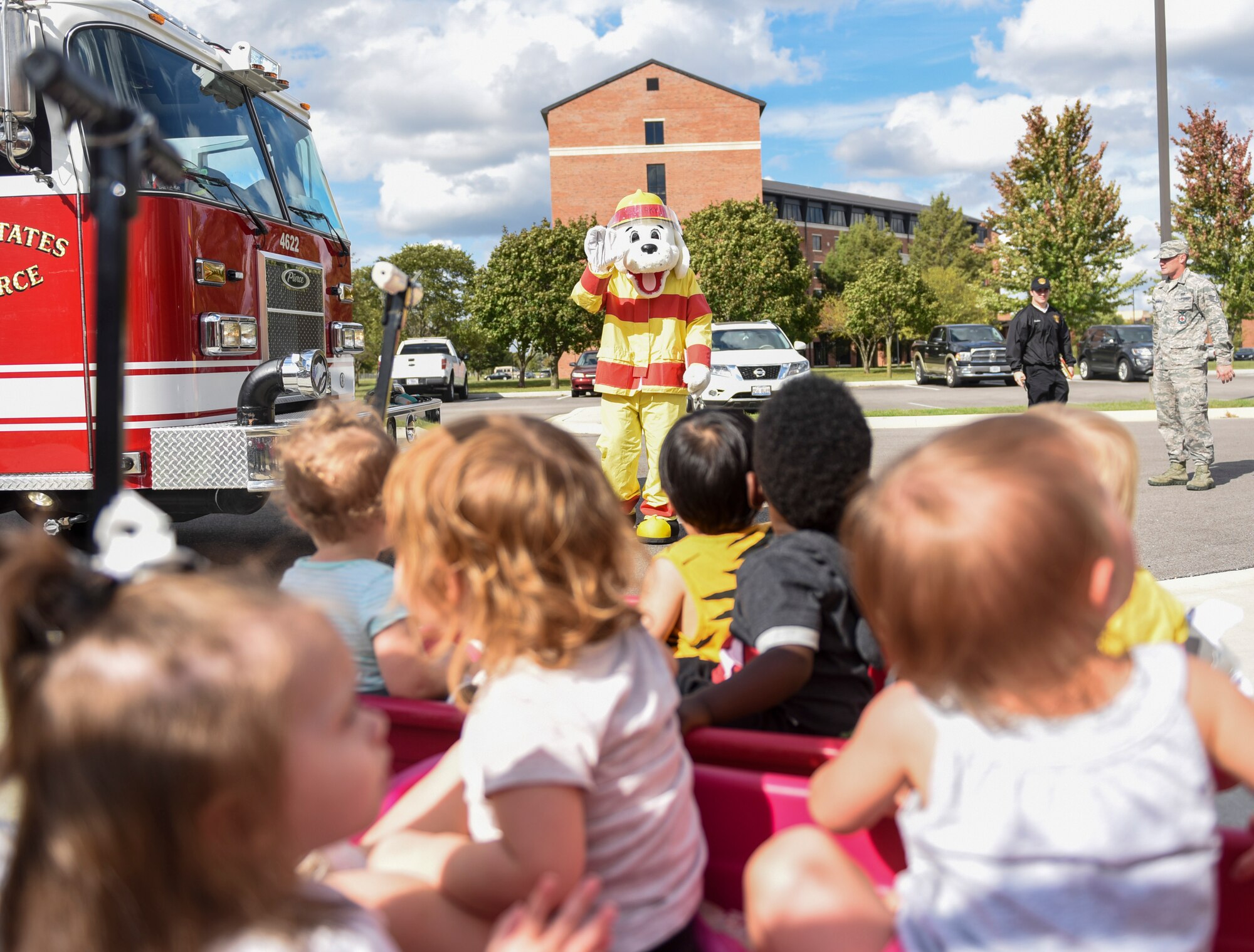 Sparky the fire dog waves to children during a visit to the Scott Air Force Base Child Development Center as part of 2018 National Fire Prevention Week, Oct. 9. Throughout the week the fire department visited the Child Development Centers, Scott Elementary School, the Scott Youth Center, hosted a puppet show at the base library, and held an open house and Fall Festival at Fire Station 2 on base. (U.S. Air Force photo by Airman 1st Class Chad Gorecki)