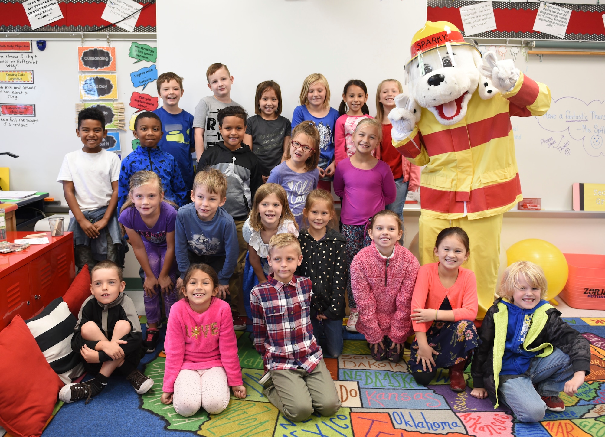 Students at the Scott Air Force Base Elementary School pose for a group picture with Sparky the fire dog during a visit by the 375th Civil Engineer Squadron Fire Department as part of 2018 National Fire Prevention Week, Oct. 11. This year, the Scott fire department approached the week with a “Look, Listen, Learn” theme to ensure the community is aware of hazards and show what they can provide. (U.S. Air Force photo by Airman 1st Class Chad Gorecki)