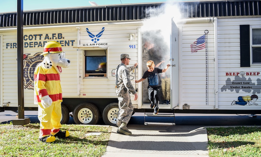 Children from the Scott Air Force Base Youth Center exit the 375th Civil Engineer “smoker” during a presentation as part of 2018 National Fire Prevention Week, Oct. 11. The smoker simulates how quickly a room can fill up with smoke and allows the opportunity to practice getting low and finding an exit during a fire. (U.S. Air Force photo by Airman 1st Class Chad Gorecki)