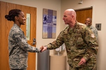 Maj. Gen. Sam Barrett, 18th Air Force commander, coins Staff Sgt. Jacqueline Lovett, 375th Medical Group, pediatrics clinic flight chief, during a three-day tour Oct. 10 - 13, 2018 at Scott Air Force Base, Illinois. “Coining” has been in the military for centuries. It is a way for leaders, to showcase their appreciation for a job well done. (U.S. Air Force photo by Senior Airman Melissa Estevez)