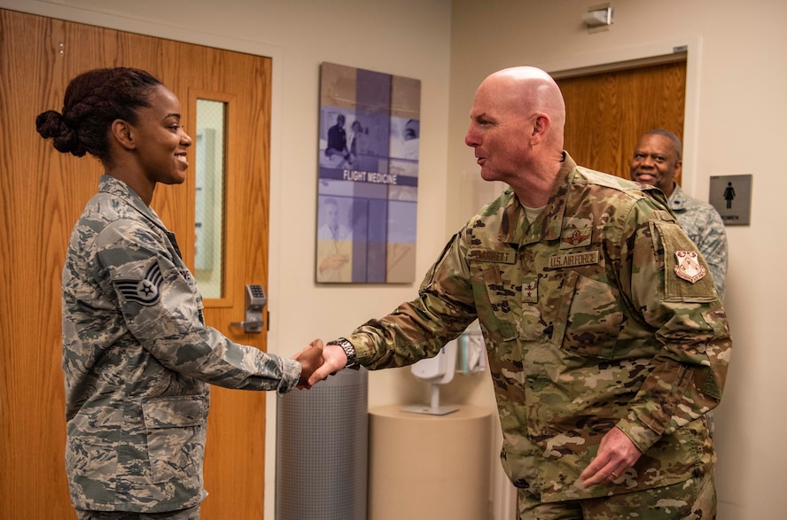 Maj. Gen. Sam Barrett, 18th Air Force commander, coins Staff Sgt. Jacqueline Lovett, 375th Medical Group, pediatrics clinic flight chief, during a three-day tour Oct. 10 - 13, 2018 at Scott Air Force Base, Illinois. “Coining” has been in the military for centuries. It is a way for leaders, to showcase their appreciation for a job well done. (U.S. Air Force photo by Senior Airman Melissa Estevez)