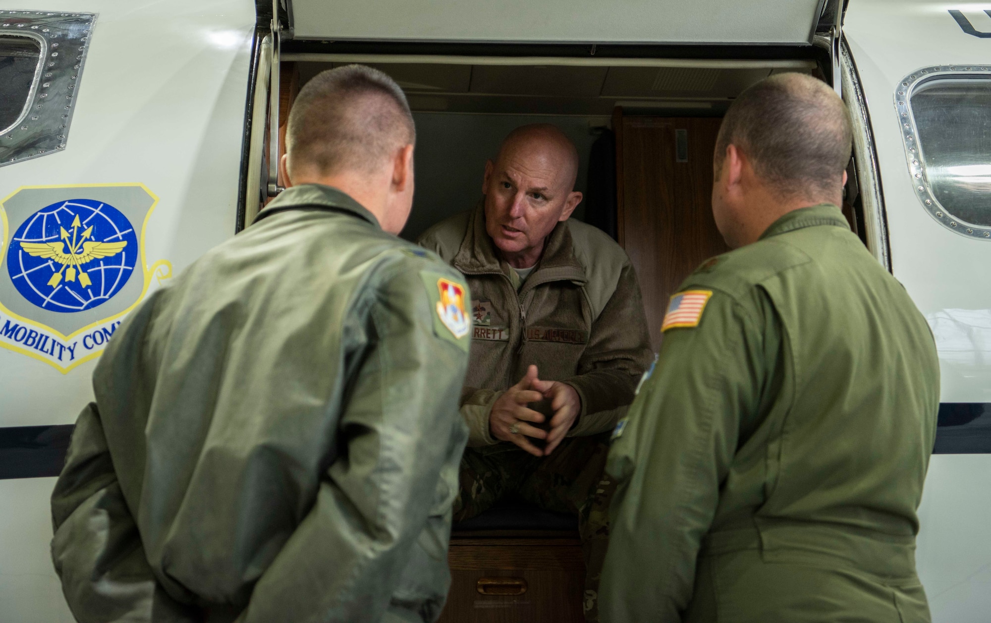 Maj. Gen. Sam Barrett, 18th Air Force commander, speaks with Col. Kevin Schiller, 375th Operations Group commander, and Maj. Taylor Todd, 458th Airlift Squadron standardizations and evaluation chief, during a three-day tour Oct. 10 - 13, 2018 at Scott Air Force Base, Illinois. During the presentation Todd spoke about C-21 highlights and improvements. (U.S. Air Force photo by Senior Airman Melissa Estevez)