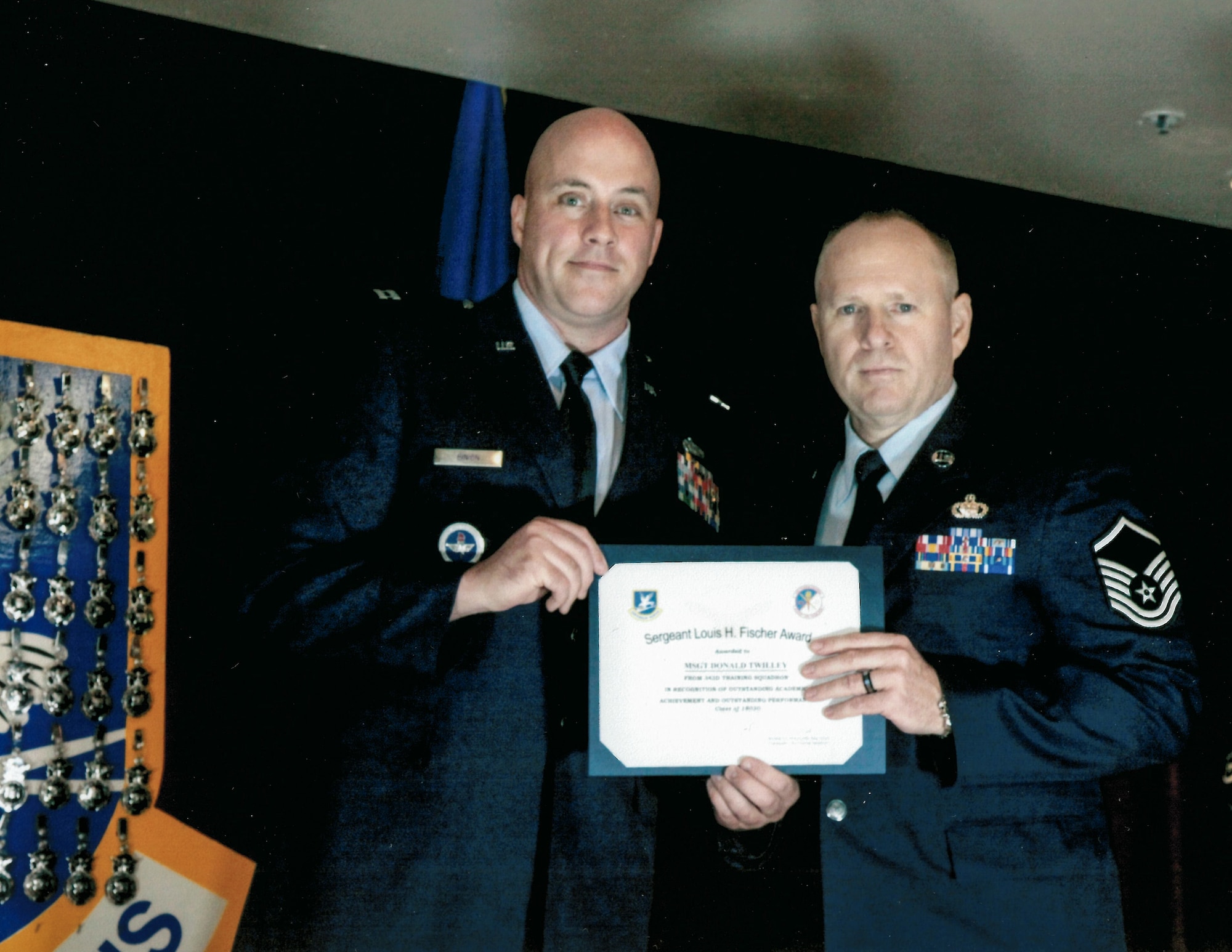 Master Sgt. Donald Twilley, right, receives the Louis H. Fisher Award during his graduation ceremony from the U.S. Air Force Security Forces Academy Apprentice Course Aug. 7, 2018, at Joint Base San Antonio-Lakeland, Texas.  The Louis H. Fischer Award is awarded to a security forces member who’s GPA is 97 percent or above, has received zero derogatory paperwork, passed all evaluations on the first attempt, earned marksmanship or “expert” with the M9 pistol, and is recommended by an instructor cadre and military training leaders. (Courtesy photo)