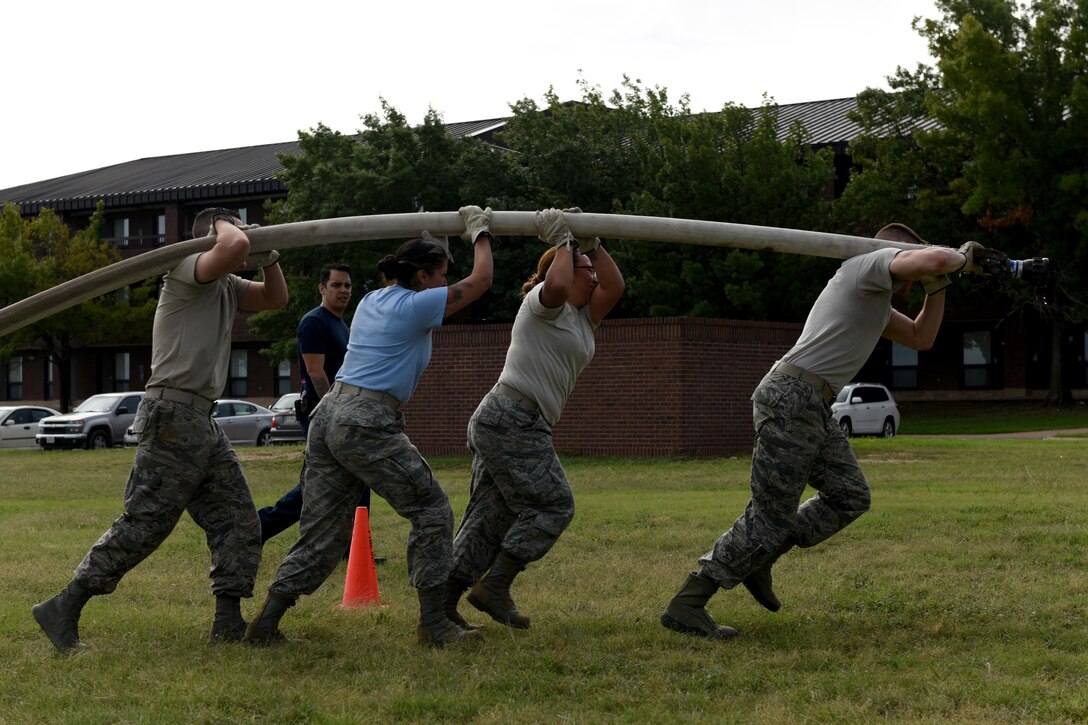 Team “1N4 Instructors” carry a fire hose during the 13th Annual Fire Muster on Goodfellow Air Force Base, Texas, Oct. 12, 2018. Participants had to carry the hose and shoot a target with the water. (U.S. Air Force photo by Senior Airman Randall Moose/Released)