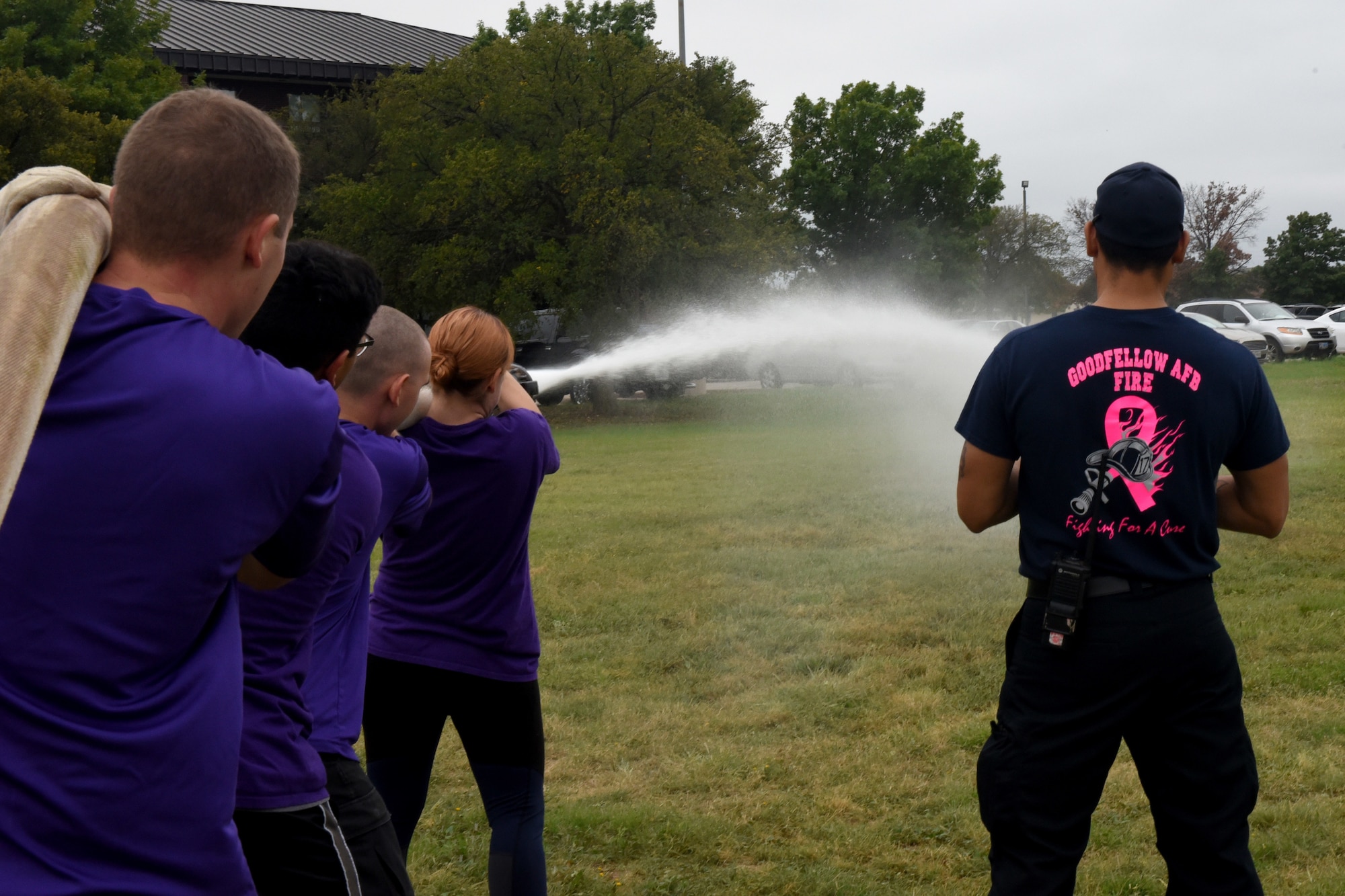 Participants shoot a charged fire hose at a target during the 13th Annual Fire Muster on Goodfellow Air Force Base, Texas, Oct. 12, 2018. This was the final challenge to complete in order to finish the relay. (U.S. Air Force photo by 2nd Lt. Matthew Stott/Released)