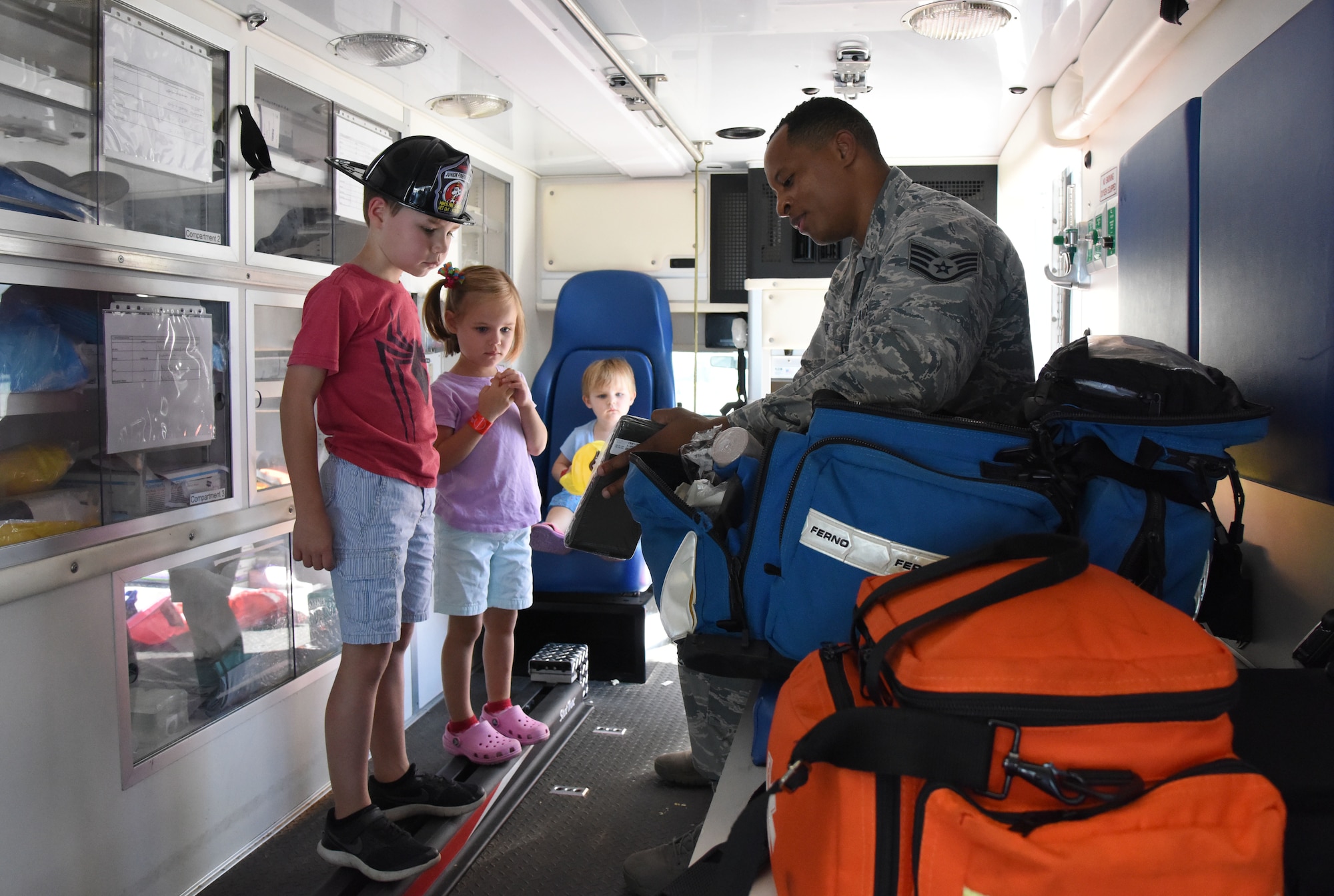 U.S. Air Force Staff Sgt. Andre White, 81st Medical Operations Squadron medical technician, speak to children about ambulance medical contents during a open house at the fire station at Keesler Air Force Base, Mississippi, Oct. 13, 2018. Keesler celebrated Fire Prevention Week by conducting random fire drills, visiting various facilities with Sparky the Fire Dog, and conducting an open house at the fire department while providing stove and fire extinguisher demonstrations. (U.S. Air Force photo by Kemberly Groue)