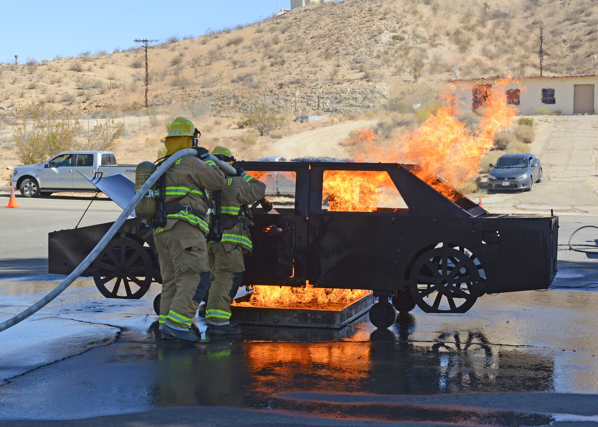 Edwards AFB fire fighters demonstrate how they would put out a car fire during an open house at Fire Station #4 at the Air Force Research Laboratory Detachment 7, Oct. 11. (U.S. Air Force photo by Kenji Thuloweit)