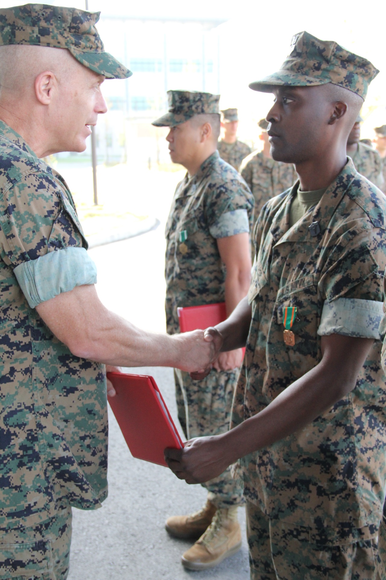 USAG CAMP HUMPHREYS, Republic of Korea – Maj. Gen. Patrick J. Hermesmann (left), commander of U.S. Marine Corps Forces Korea, awards Petty Officer 1st Class Andre Cooper, head medical representative for MARFORK, a Navy and Marine Corps Achievement Medal here, Oct. 4. MARFORK awarded Cooper for his contributions to the unit, which ensured their readiness to support the mission. (U.S. Marine Corps photo by Staff Sgt. Anthony Kirby/Released)