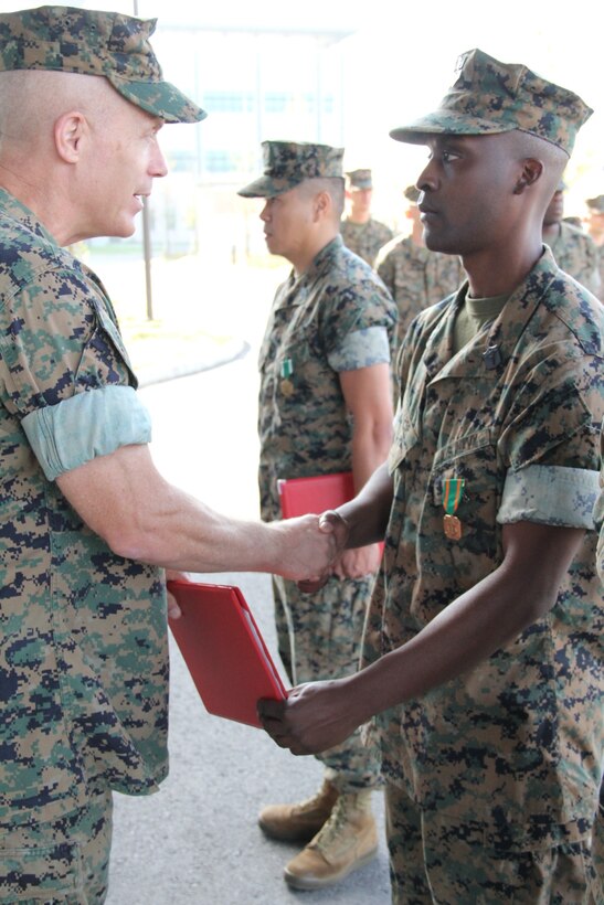 USAG CAMP HUMPHREYS, Republic of Korea – Maj. Gen. Patrick J. Hermesmann (left), commander of U.S. Marine Corps Forces Korea, awards Petty Officer 1st Class Andre Cooper, head medical representative for MARFORK, a Navy and Marine Corps Achievement Medal here, Oct. 4. MARFORK awarded Cooper for his contributions to the unit, which ensured their readiness to support the mission. (U.S. Marine Corps photo by Staff Sgt. Anthony Kirby/Released)