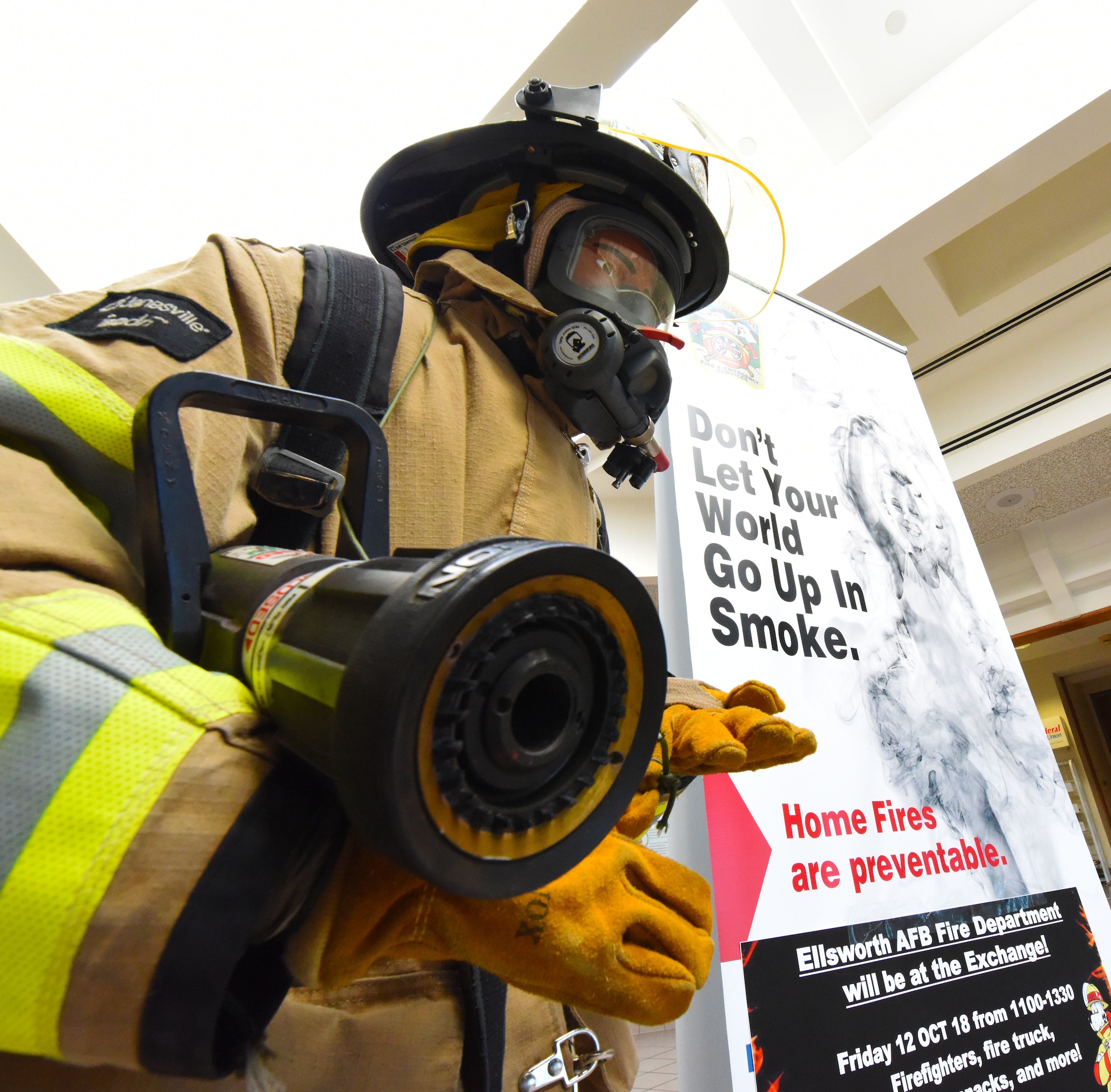 A training dummy dressed like a firefighter stands next to a fire prevention poster at the Exchange on Ellsworth Air Force Base, S.D., Oct. 10, 2018. The 28th Civil Engineer Squadron fire protection flight hosted events, such as a firefighter challenge, a parade and fire safety demonstrations, at Ellsworth AFB and in Box Elder during National Fire Prevention and Safety Week. (U.S. Air Force photo by Airman 1st Class Thomas Karol)