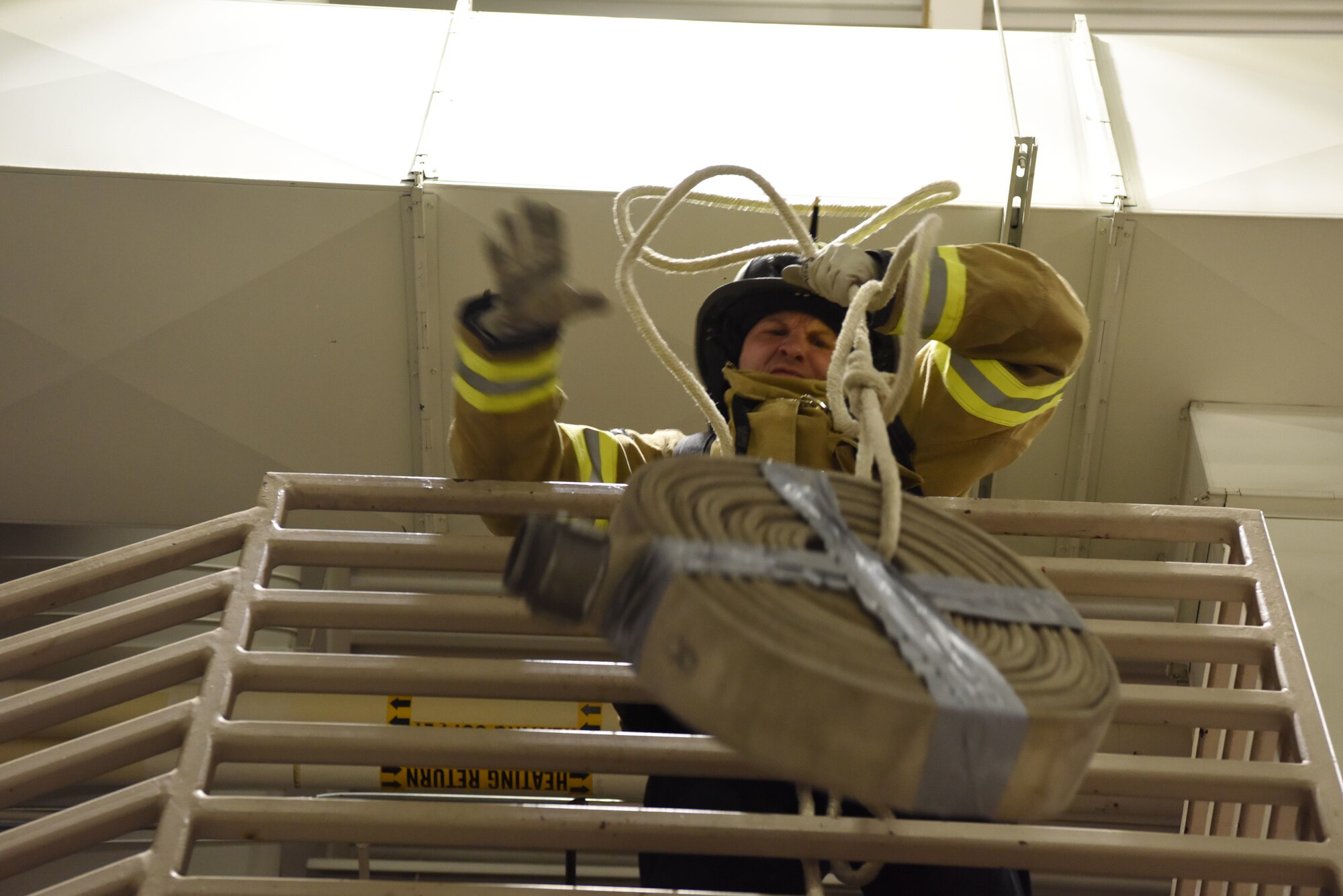 Senior Master Sgt. Joshua Beutler, the 28th Aircraft Maintenance Squadron first sergeant, pulls a rope with an attached hose over a stair railing at Ellsworth Air Force Base, S.D., Oct. 5, 2018. Several squadrons on base formed teams to compete in the Firefighter Challenge, one of the many events hosted by the 28th Civil Engineer Squadron fire protection flight during National Fire Prevention and Safety Week. (U.S. Air Force photo by Airman 1st Class Thomas Karol)