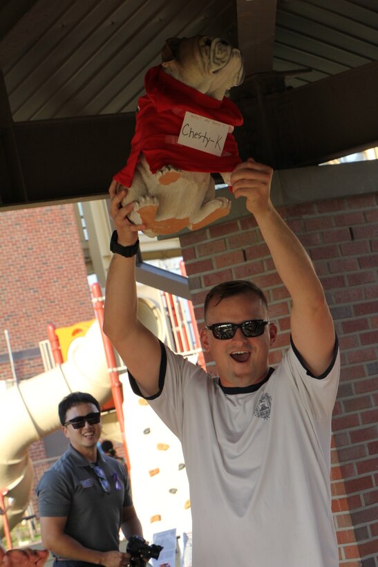 USAG CAMP HUMPHREYS, Korea – 1st Lt. Andrew Snyder, U.S. Marine Corps Forces Korea G-33 assistant current operations officer, holds up “Chesty-K,” the mascot of MARFORK, following the kickball tournament at its Family Day event here, Oct 4. The event drew Marine families from around the Korean peninsula to provide food, fun, and information in an inclusive environment.  (U.S. Marine Corps photo by Staff Sgt. Anthony Kirby/Released)