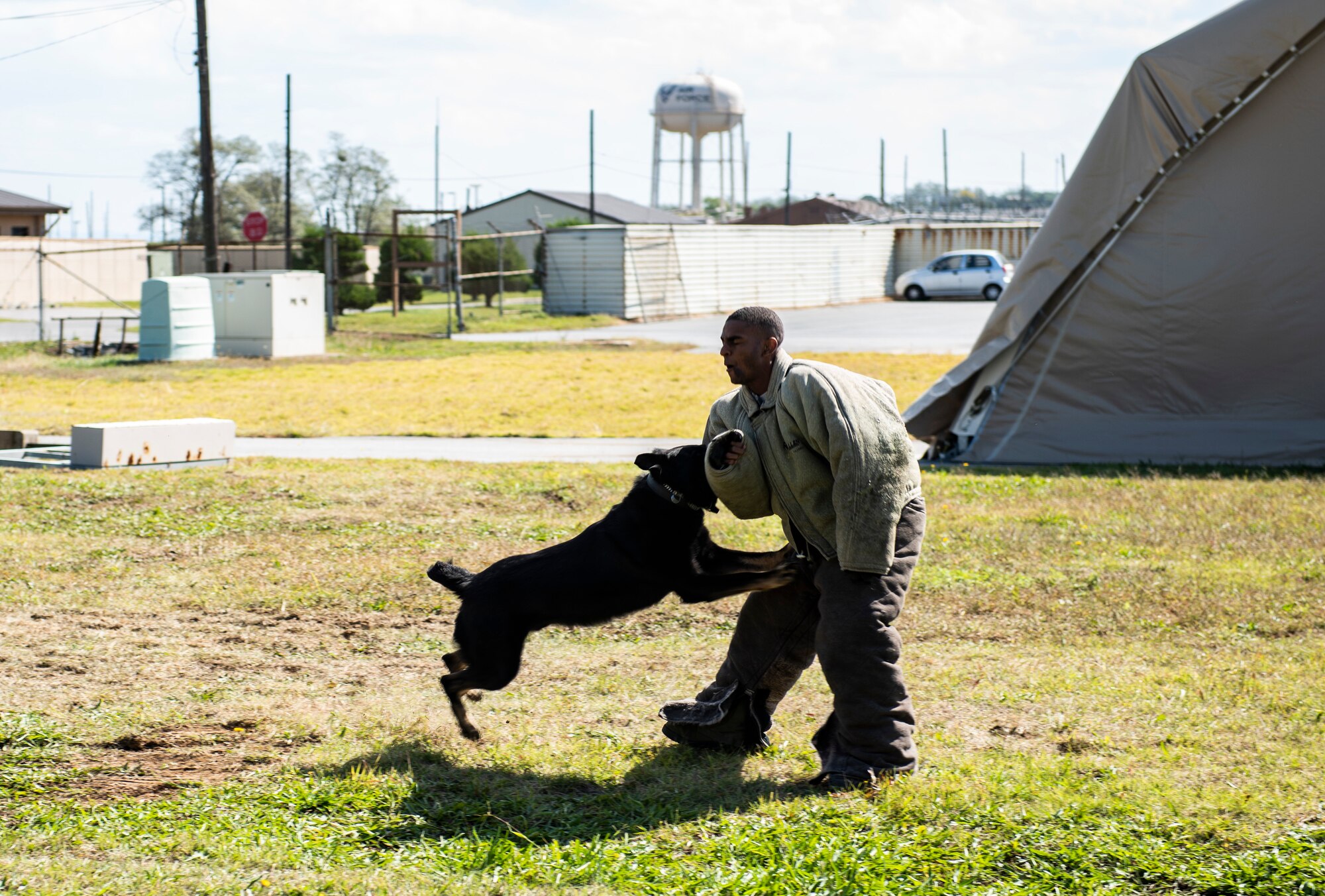 U.S. Air Force Airman 1st Class Joseph Mixon, 8th Civil Engineering Squadron fire fighter, trains with a 8th Security Forces Squadron military working dog at Kunsan Air Base, Republic of Korea, Oct. 11, 2018. Security forces demonstrated various commands with a canine for students from Su Song Elementary School to showcase their capabilities during the fire department’s open house. (U.S. Air Force photo by Senior Airman Stefan Alvarez)