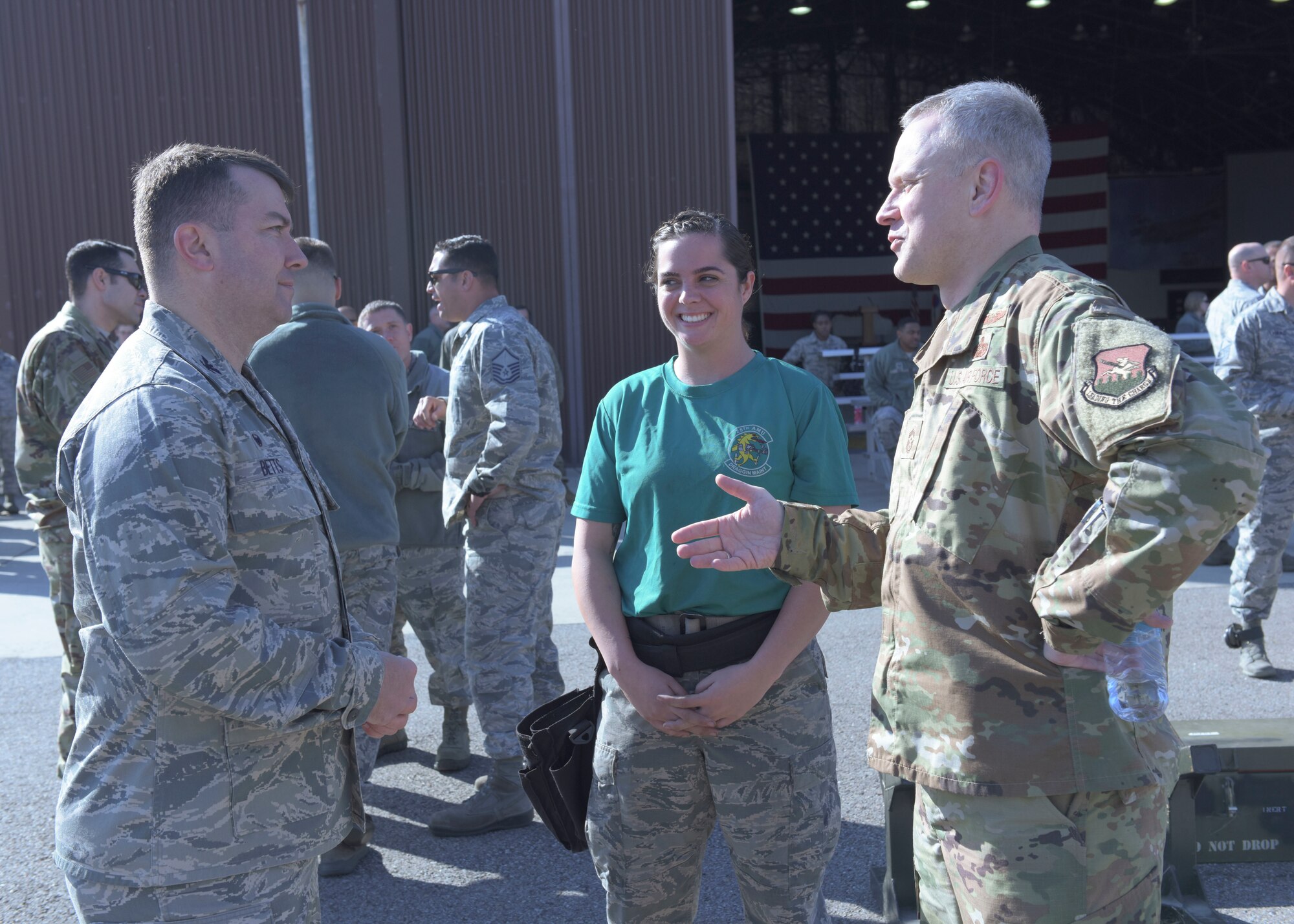 U.S. Air Force Airman 1st Class Danielle Decker a weapons load crew member with the 51st Aircraft Maintenance Squadron, center, is congratulated by U.S. Air Force Col. William Betts, 51st Fighter Wing commander, and Chief Master Sgt. Philip Hudson, 51st Fighter Wing command chief, after a load crew competition on Osan Air Base, Oct. 12, 2018. Leadership involves themselves in base events as a way to motivate and encourage Airmen. (U.S. Air Force photo by Staff Sgt. Timothy Dischinat)