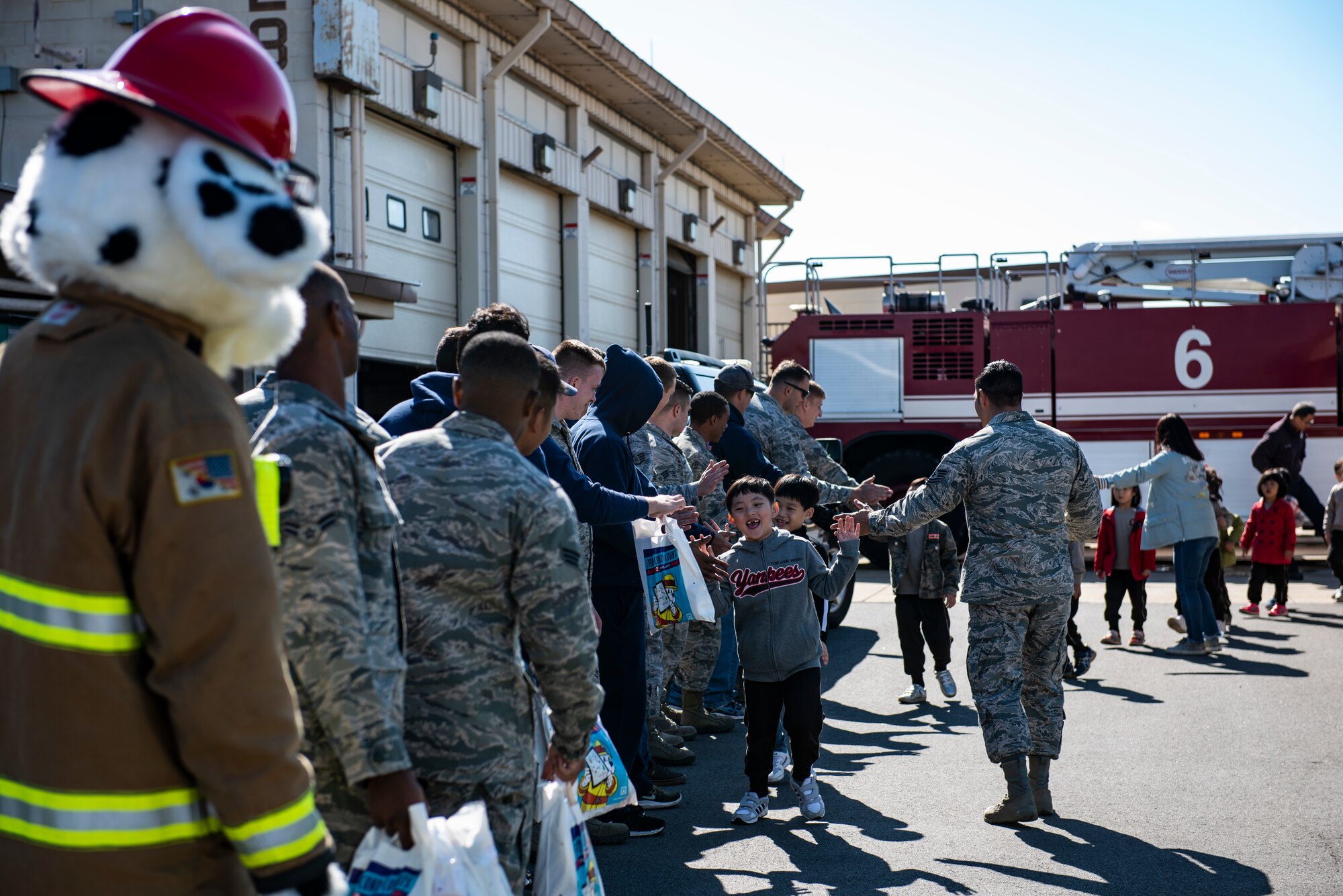 Members of the 8th Civil Engineering Squadron fire department hand out gift bags to students during an open house at Kunsan Air Base Republic of Korea, Oct. 11, 2018. The Kunsan Fire Department welcomed 60 students from a local school to show them some of the equipment they use and teach them about fire safety. (U.S. Air Force photo by Senior Airman Stefan Alvarez)