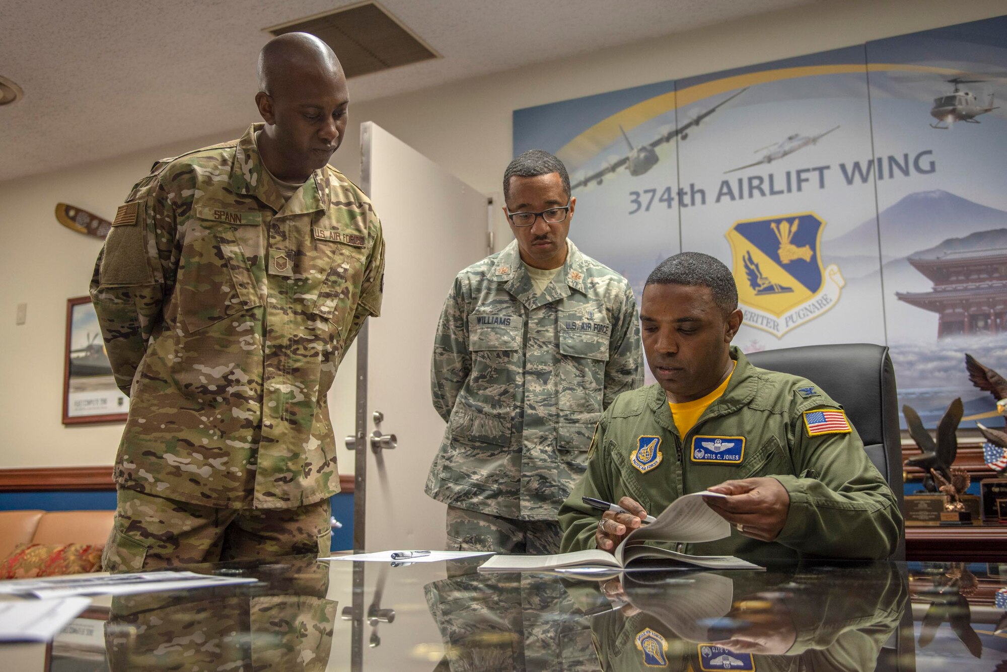 Col. Otis C. Jones, 374th Airlift Wing commander, flips through the 2018 charity listing booklet prior to naming his cause for the Combined Federal Campaign set to kick-off at Yokota Air Base, Japan, Oct. 12, 2018.