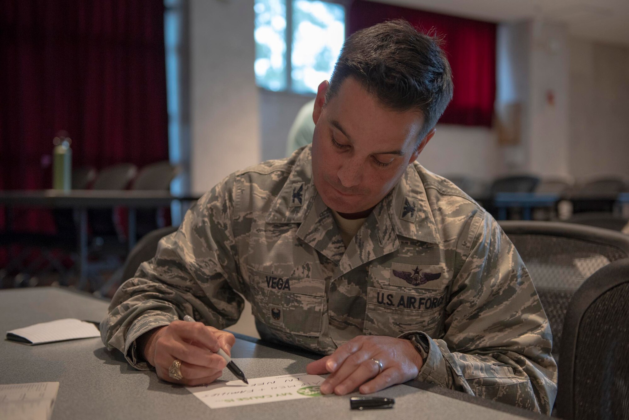 Col. Sergio Vega, 374th Airlift Wing vice commander, completes his cause card at the kick-off event for the Combined Federal Campaign at Yokota Air Base, Japan, Oct. 15, 2018.