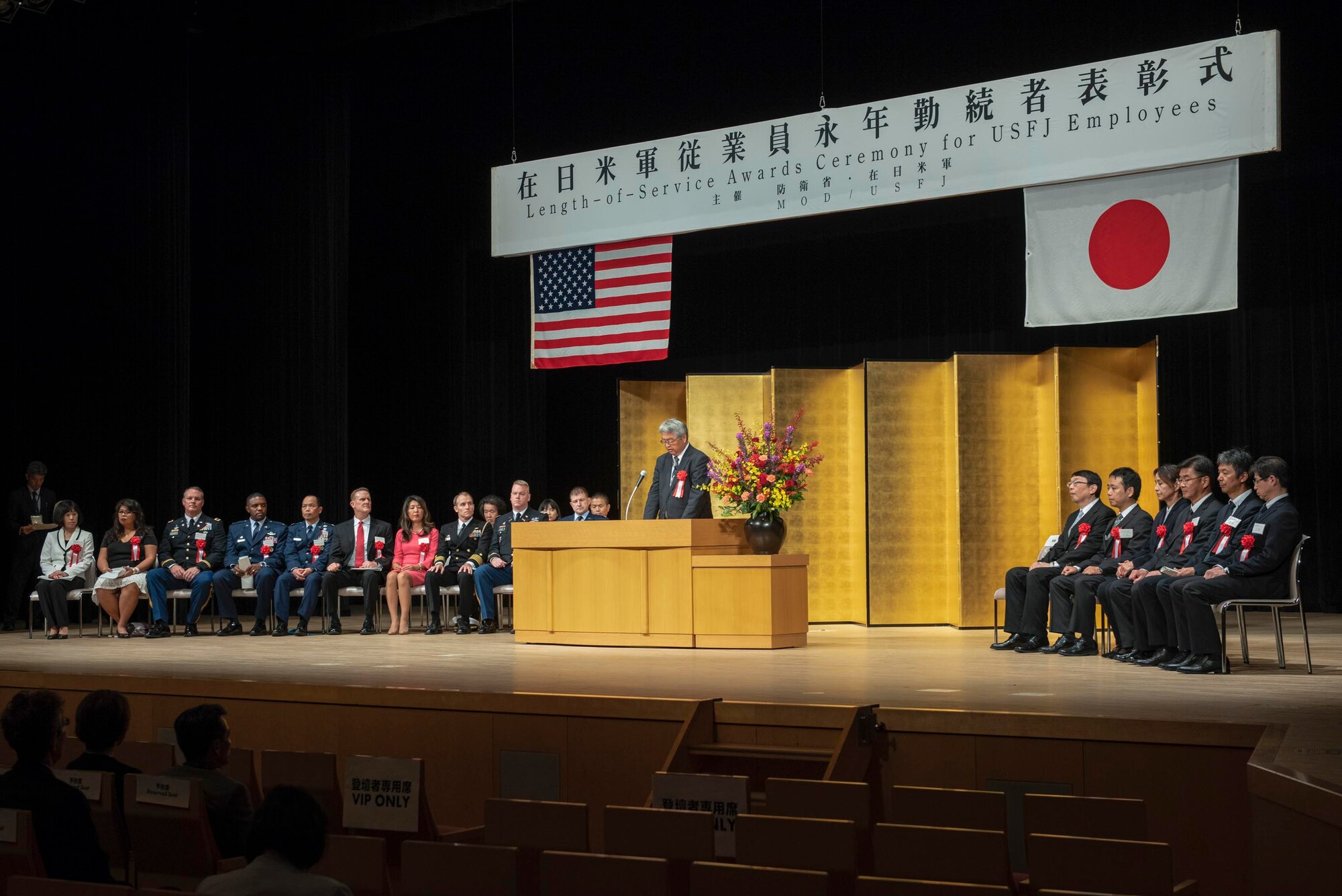 Koutarou Yoshida, North Kanto Defense Bureau director general, delivers the opening remarks during the United States Forces Japan Length-of-Service Awards Ceremony at Yutorogi Hall in Hamura City, Japan, Oct. 10, 2018.