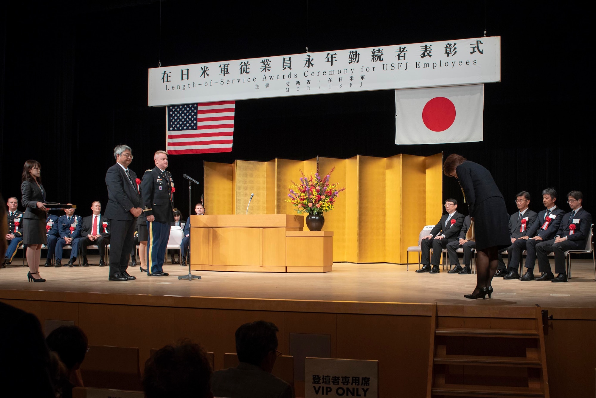 Rie Miyoshi, Stars and Stripes Tokyo management analyst, bows as a sign of respect after receiving an award for her years of service at the USFJ Length-of-Service Awards Ceremony at the Yutorogi Hall in Hamura City, Japan, Oct. 10, 2018.