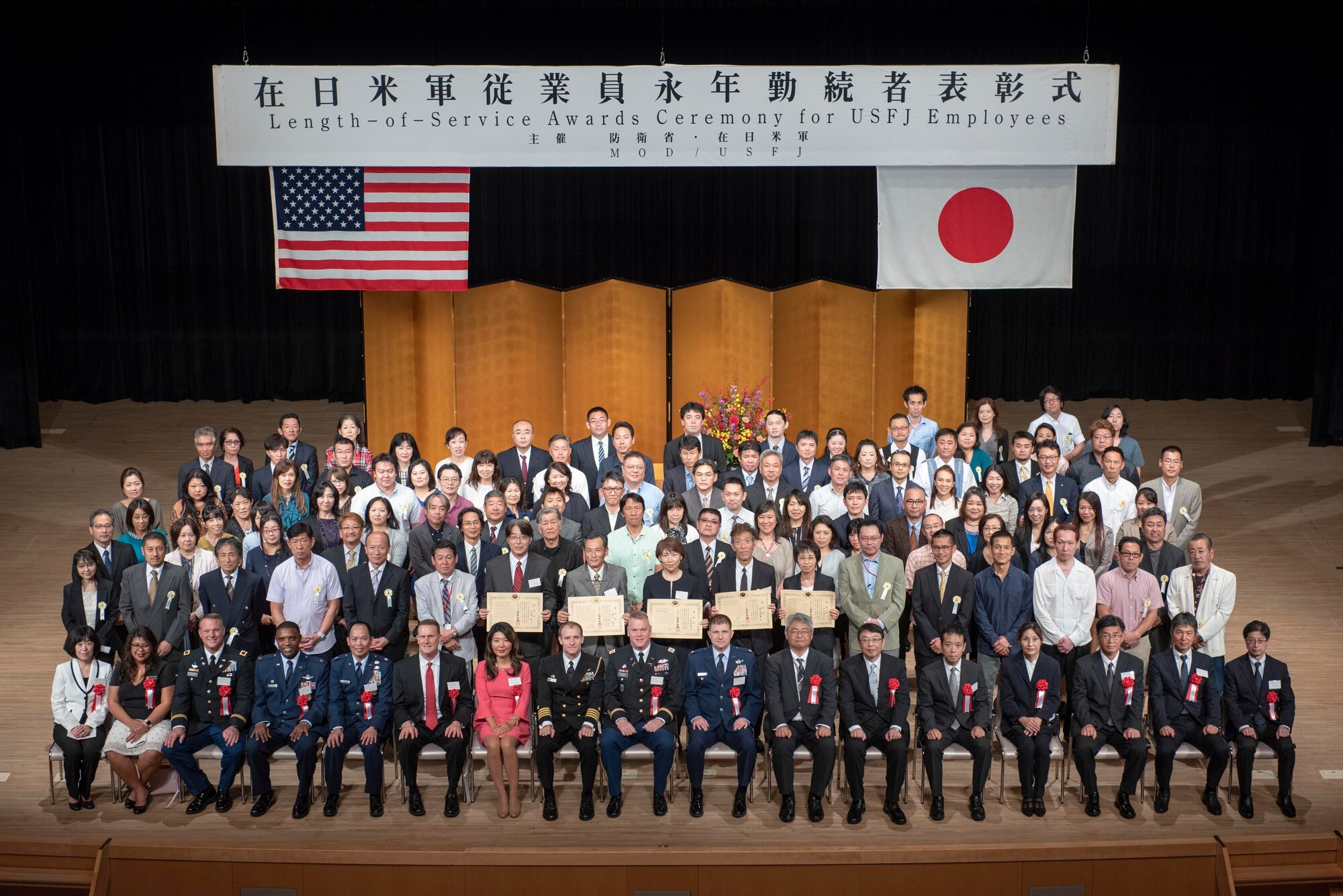 Award winners and distinguished guests pose for a photo at the conclusion of the United States Forces Japan Length-of-Service Awards Ceremony at the Yutorogi Hall in Hamura City, Japan, Oct. 10, 2018.