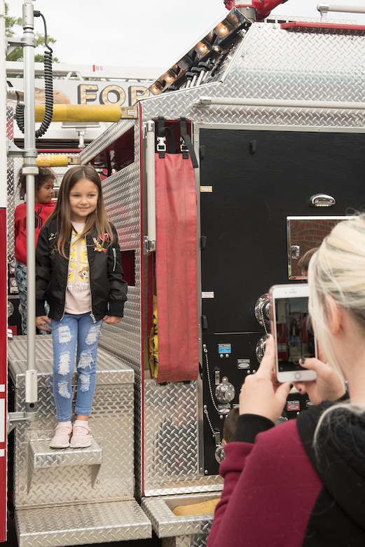 Ellie Hall, age 6, daughter of U.S. Army Pvt. Nicholas Hall, 331st Transportation Company, 11th Transportation Battalion, 7th Transportation Brigade (Expeditionary) watercraft operator, poses for a photo on a fire truck during the Fort Eustis Fire and Emergency Services Open House event at Joint Base Langley-Eustis, Va., Oct. 13, 2018.