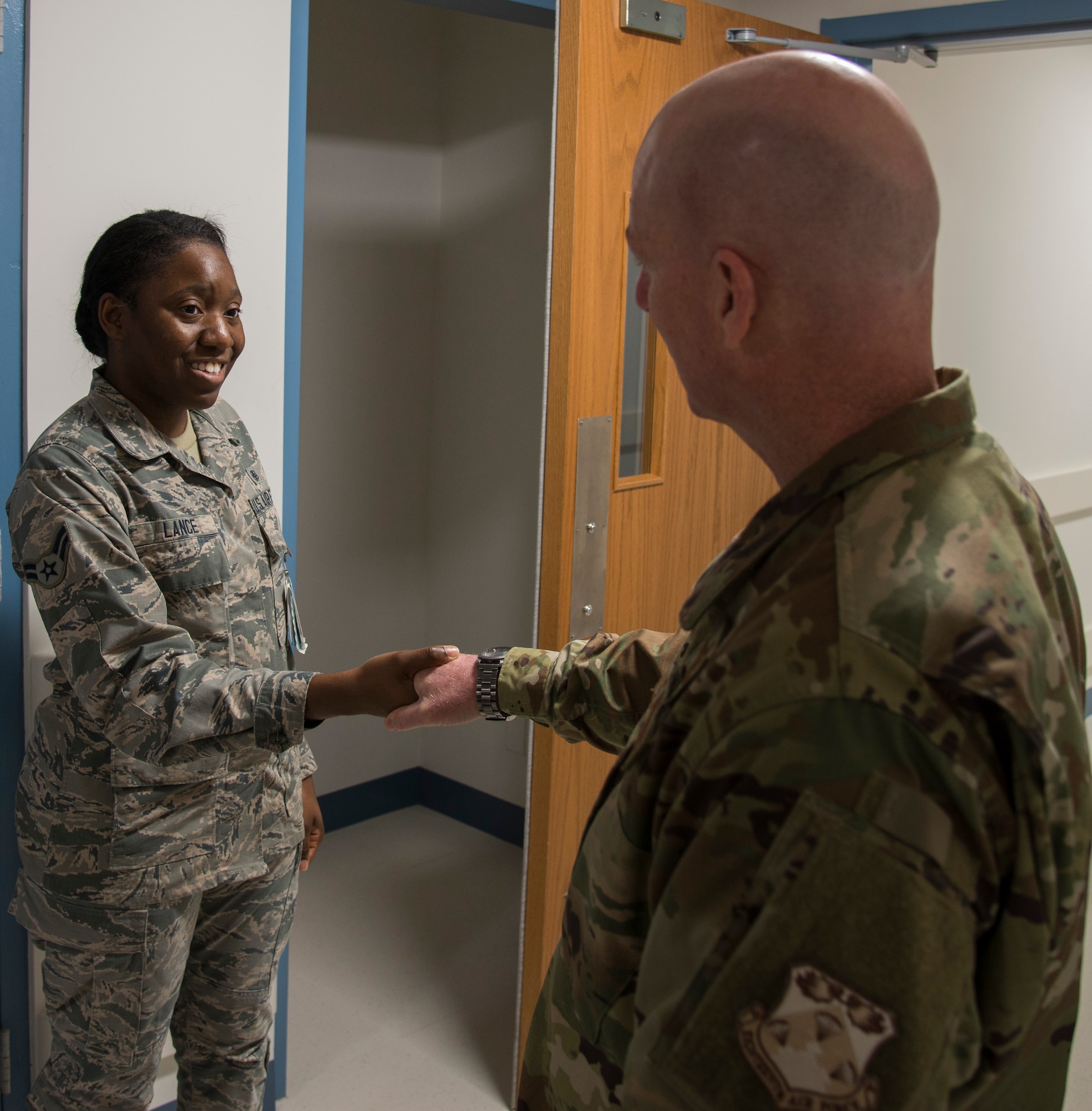 Maj. Gen. Sam Barrett, 18th Air Force commander, coins Dominique Lance, 375th Medical Support Squadron medical material technician, during his visit to the 375th Medical Group on Oct. 11, 2018, at Scott Air Force Base, Illinois. (U.S. Air Force photo by Airman 1st Class Nathaniel Hudson)