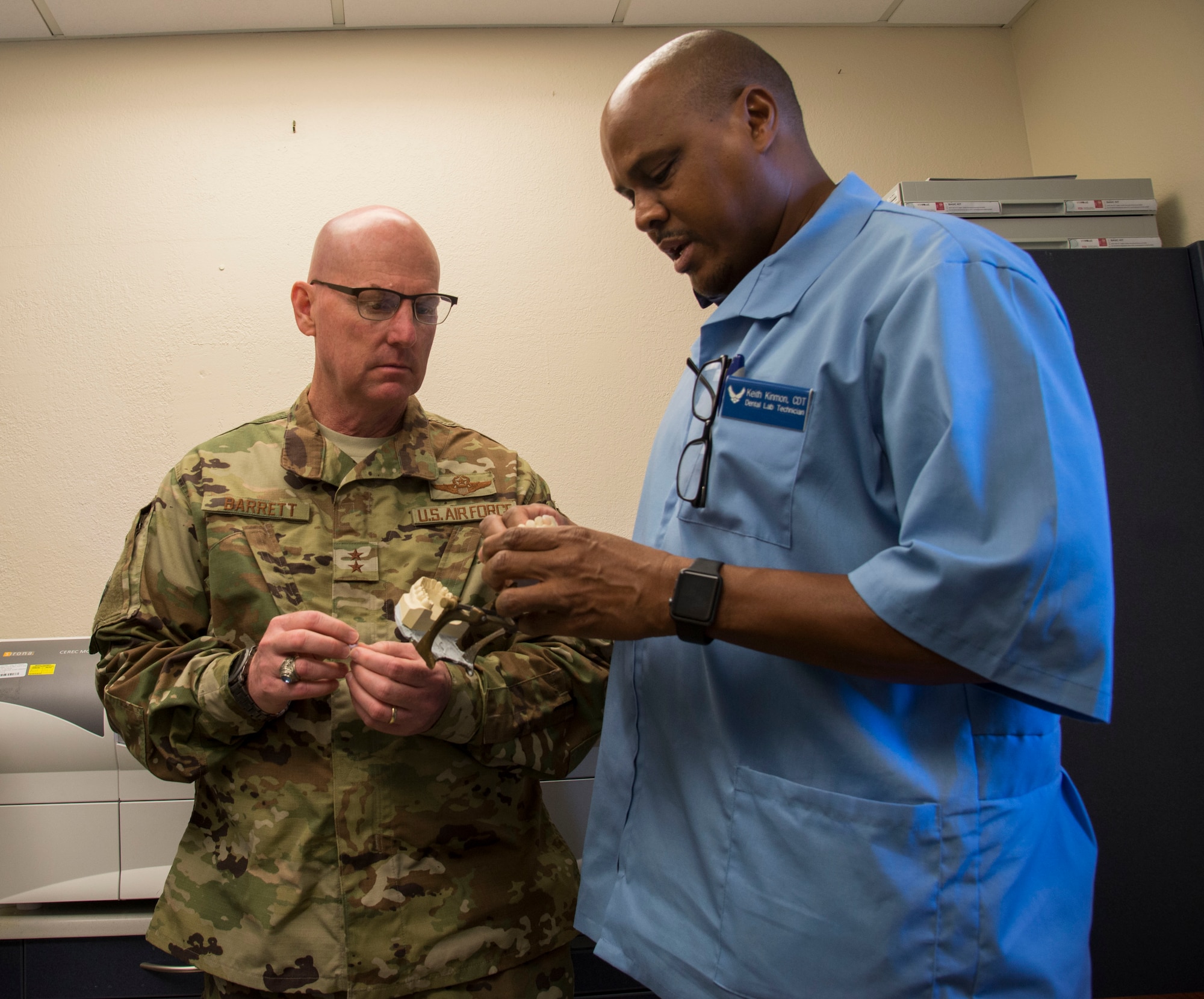 Maj Gen. Sam Barrett, 18th Air Force commander, is shown the process to make a dental crown by Keith Kimmon 375th Dental Squadron dental lab technician, Oct.11, 2018, at Scott Air Force Base, Illinois. The 375th Dental squadron is responsible for providing dental care to all members of Scott AIR FORCE BASE. (U.S. Air Force photo by Airman 1st Class Nathaniel Hudson)