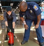 firefighter gives food service worker fire extinguisher training