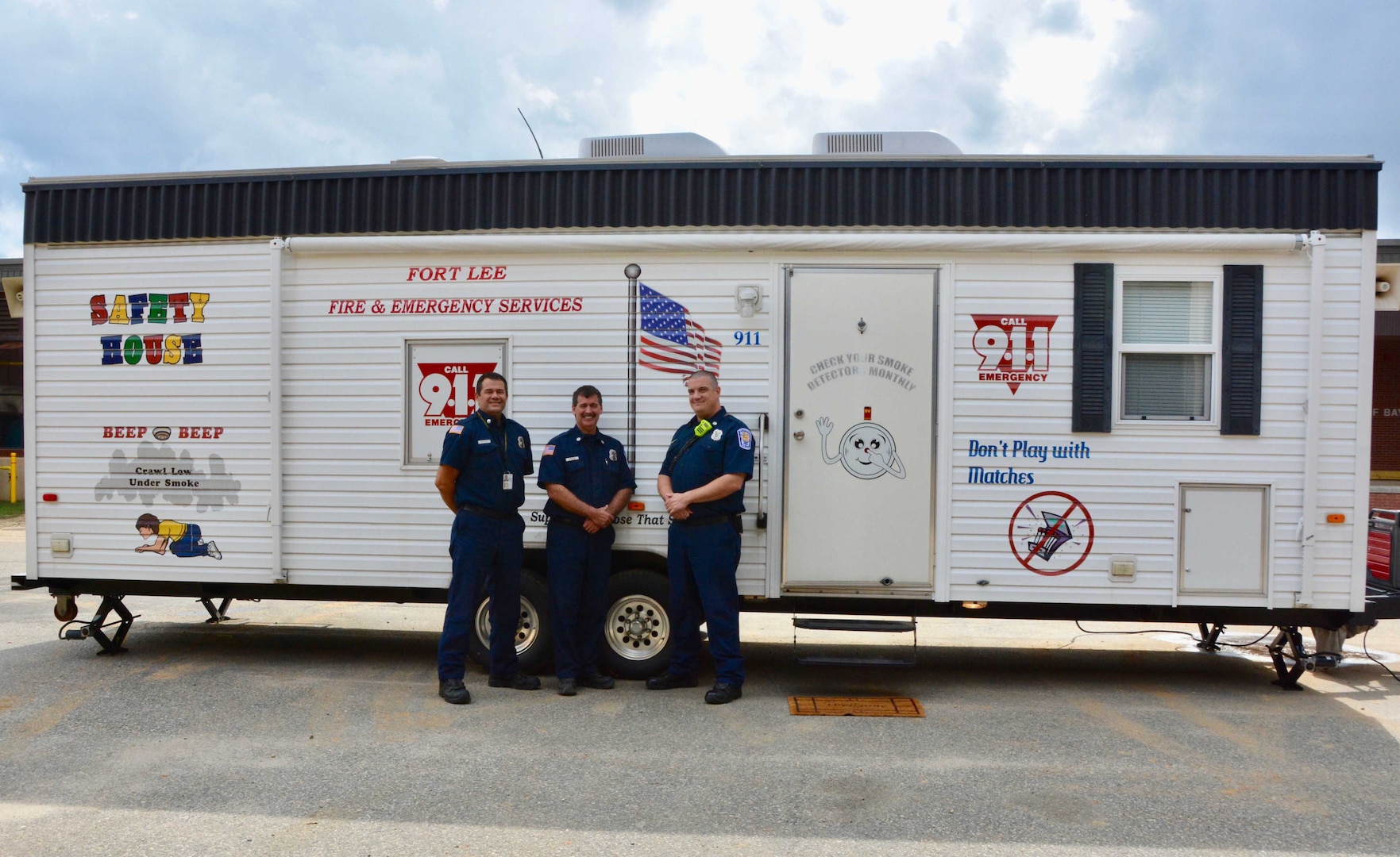 firefighters stand in front of fire Safety House