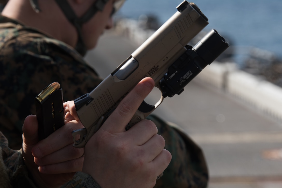 A reconnaissance Marine with the 31st Marine Expeditionary Unit’s Amphibious Reconnaissance Platoon reloads an M1911 .45-caliber pistol aboard the flight deck of the amphibious assault ship USS Wasp, underway in the East China Sea, Oct. 15, 2018. The 31st MEU, the Marine Corps’ only continuously forward-deployed MEU, provides a flexible force ready to perform a wide range of military operations.