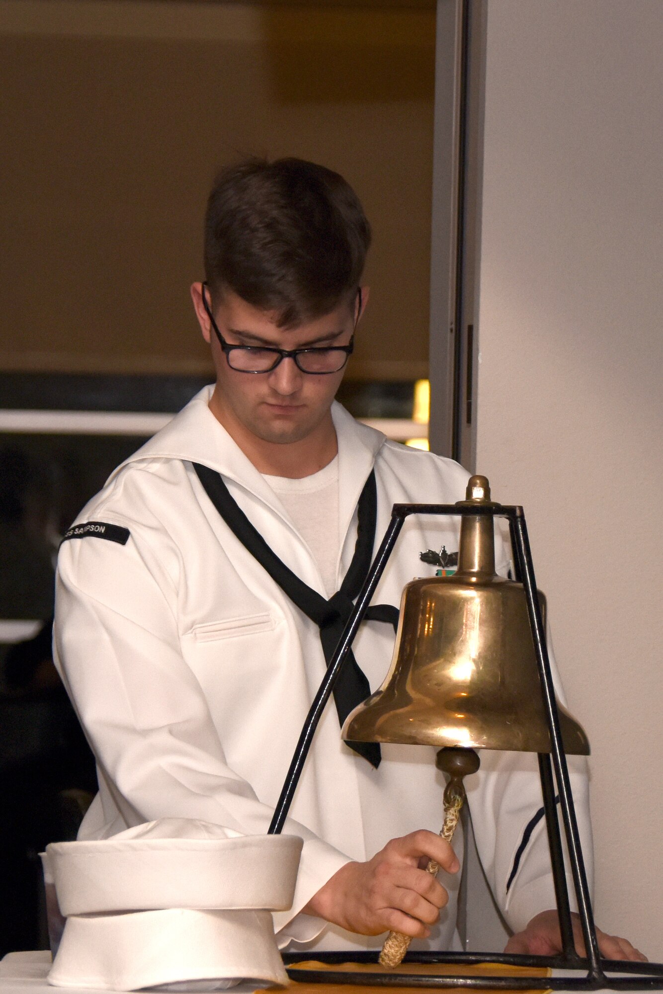 U.S. Navy Petty Officer 2nd Class Garret Van Sickle, student at the Navy Center for Information Warfare Training student, ceremonially rings a bell nine times during the 243rd Navy Day Ball, eight to symbolize the end of the year, and one to welcome the next year, during the ball at the Event Center on Goodfellow Air Force Base, Texas, Oct. 12, 2018. In addition to ringing the bell, the ceremony included, posting the colors, a guest speaker and cutting of the cake. (U.S. Air Force photo by Airman 1st Class Seraiah Hines/Released)