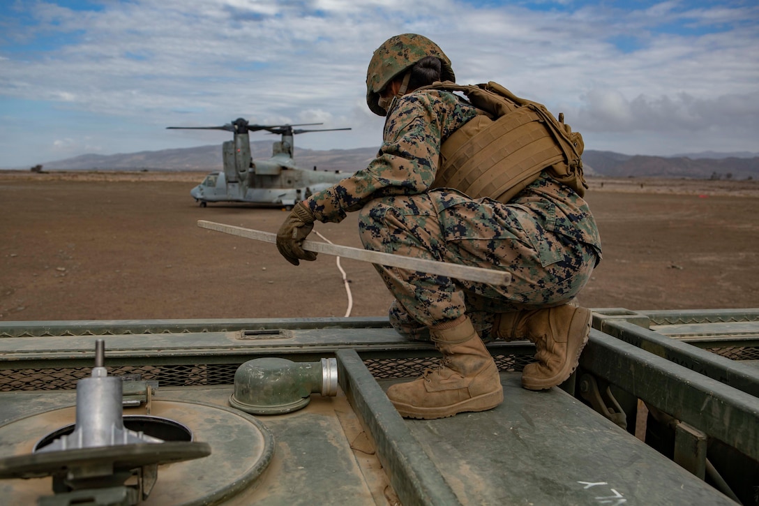 U.S. Marine PFC. Anel Sarmiento, a motor vehicle operator assigned to Service Company, 9th Communications Battalion, I Marine Expeditionary Force Information Group, checks the fuel tank level during the fuel transfer from a MV-22B Osprey to 7-ton truck carrying a fuel tank during an air-ground refueling operation at Marine Corps Base Camp Pendleton, California, Oct. 2, 2018. Air-ground refueling provides an alternative method to obtain fuel in a deployed environment when ground transportation is not available. (U.S. Marine Corps photo by Cpl. Cutler Brice)