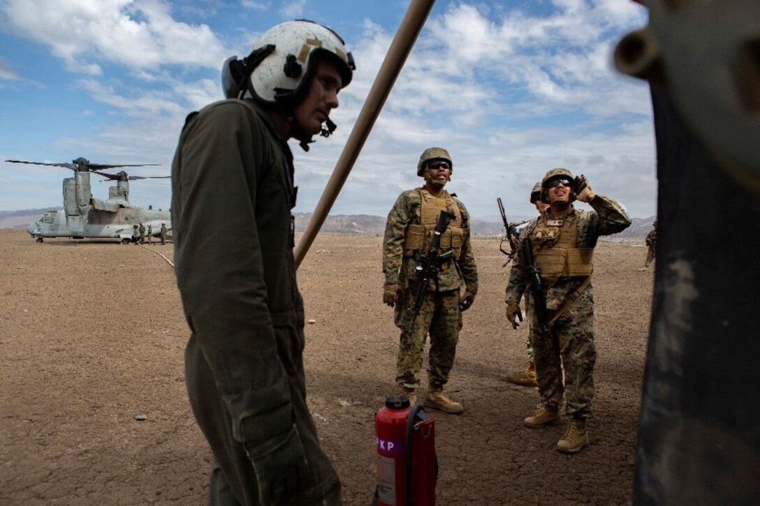 U.S. Marines assigned to Service Company, 9th Communications Battalion and Marine Medium Tiltrotor Squadron (VMM) 364, 3rd Marine Aircraft Wing, monitor the fuel transfer from a MV-22B Osprey to 7-ton truck carrying a fuel tank during an air-ground refueling operation at Marine Corps Base Camp Pendleton, California, Oct. 2, 2018. Air-Ground refueling provides an alternative method to obtain fuel in a deployed environment when ground transportation is not available. (U.S. Marine Corps photo by Cpl. Cutler Brice)