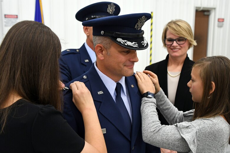 Family members of Col. Brad Douglass help pin the colonel rank on his dress uniform during a promotion and assumption of command ceremony held Oct. 13, 2018 at Dobbins Air Reserve Base, Ga. Most recently, he held an Individual Mobilization Augmentee position at the Pentagon where he worked with the A4 Nuclear Weapons, Missiles and Munitions Division. (U.S. Air Force photo/Senior Airman Josh Kincaid)