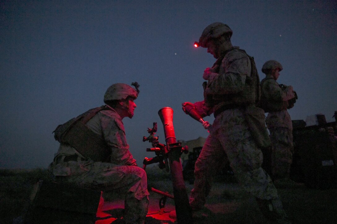 Marines wait for the order to fire a mortar at night.