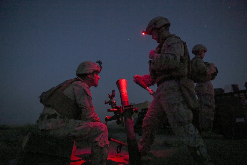 Marines wait for the order to fire a mortar at night.
